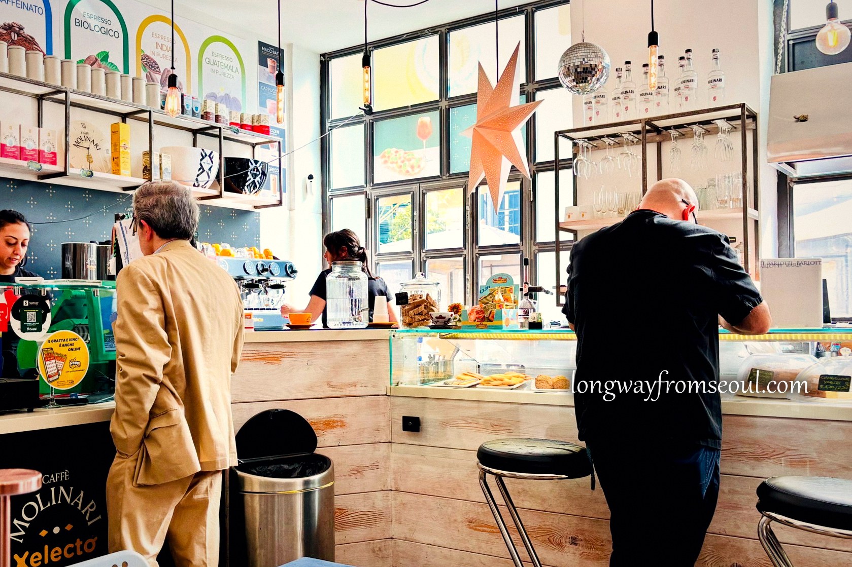 Locals drinking espresso standing at the bar of a Rome café