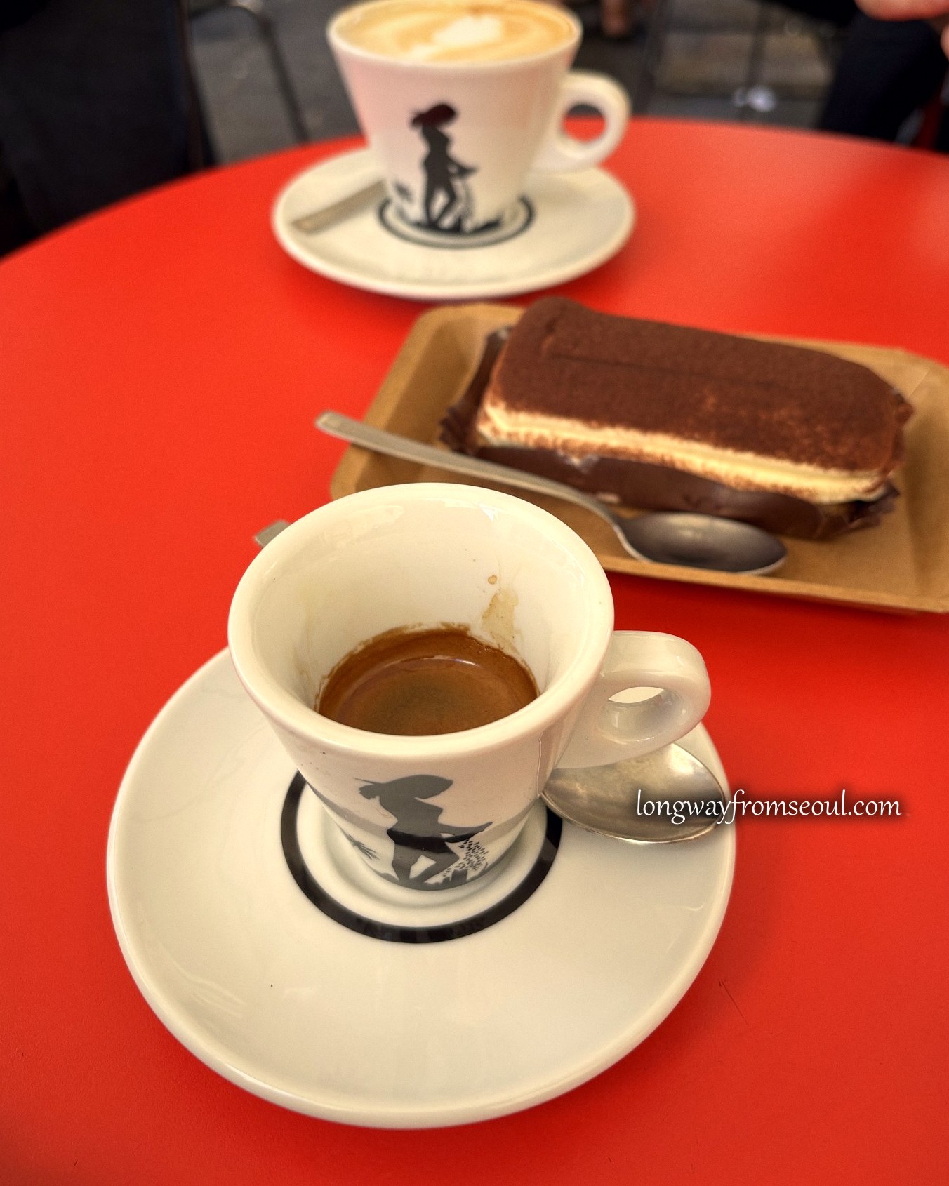Espresso, cappuccino and tiramisu on a red café table near the Pantheon