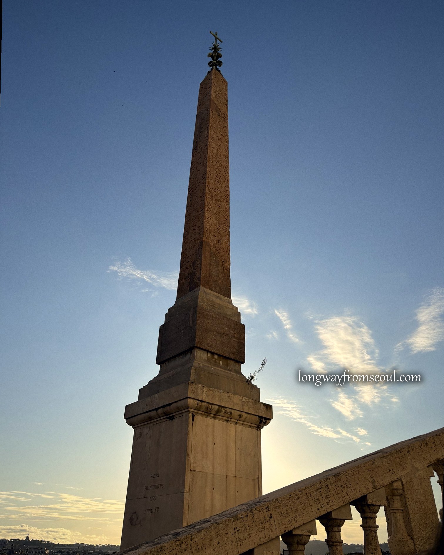 An Egyptian obelisk silhouetted against the Rome sunset sky