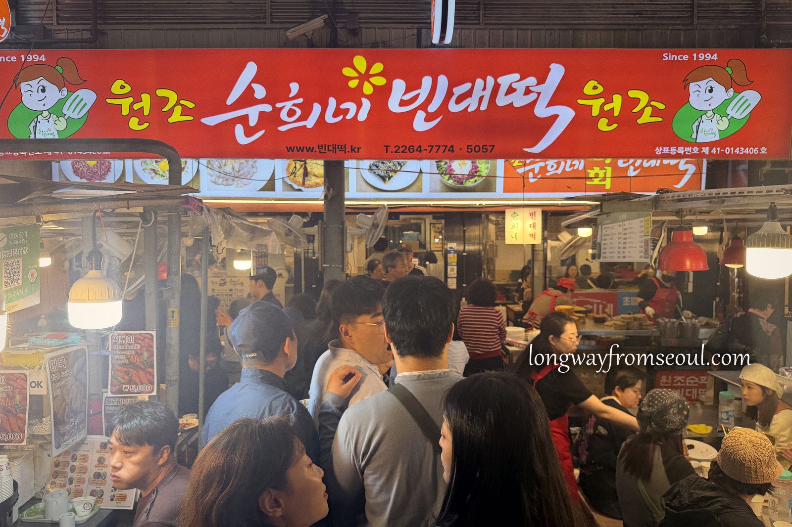 The red sign and crowded counter of Sunhui-ne Bindaetteok inside Gwangjang Market, Seoul