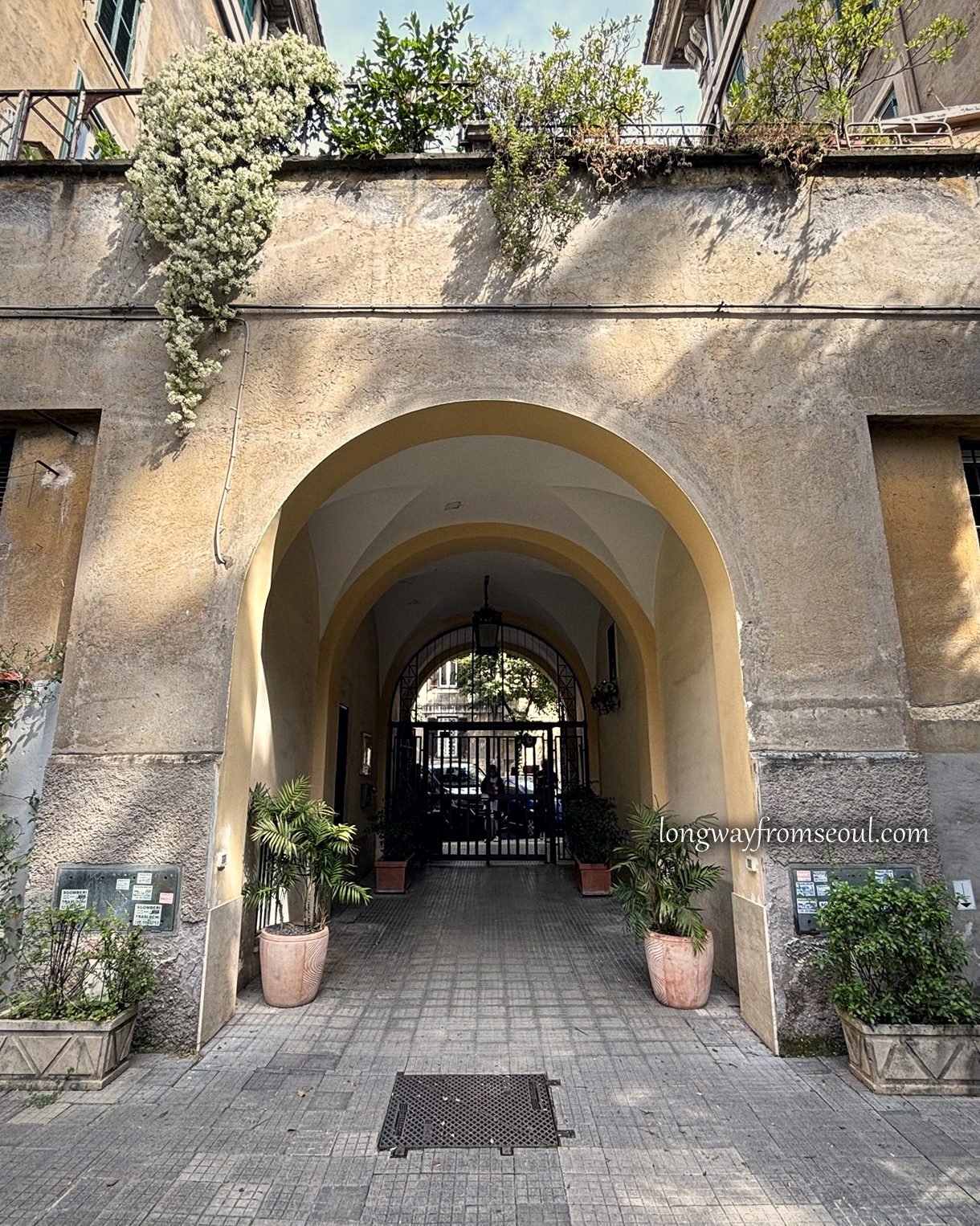 A stone archway leading out of a residential courtyard in Prati, Rome