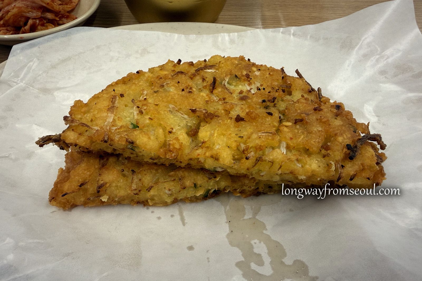 Close-up of golden fried Korean mung bean pancakes on white paper