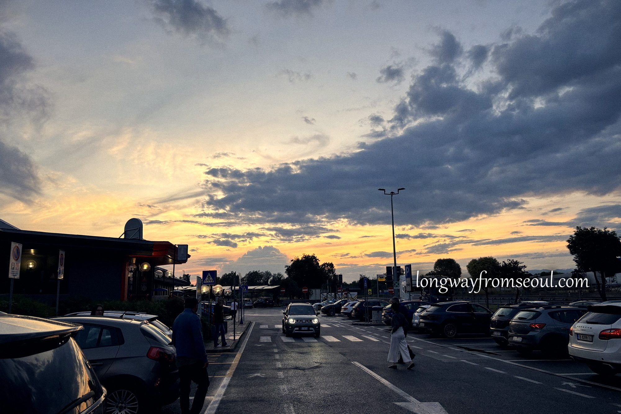 An Italian motorway service station car park at sunset