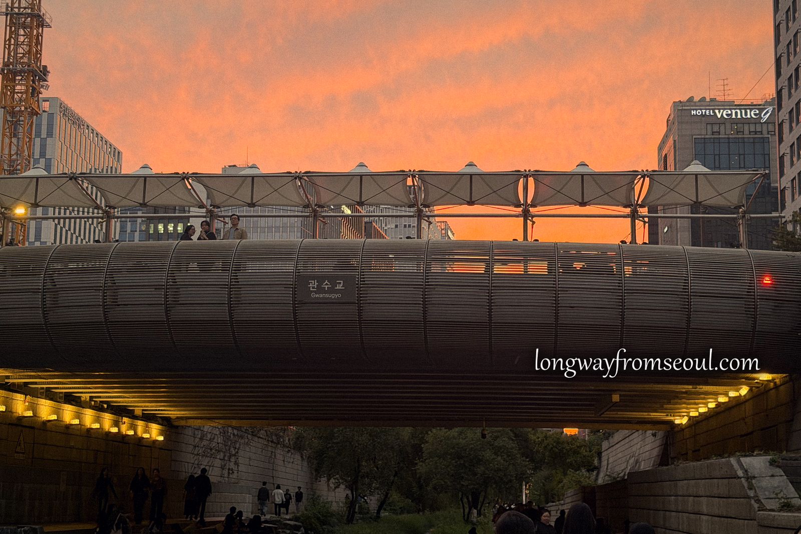The Cheonggyecheon stream at dusk with bridge lights reflected in the water